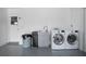 Modern garage laundry area complete with sink, storage and front load washer and dryer at 800 Everest Rd, Venice, FL 34293
