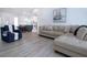 Bright living room with wood-look floors, comfortable seating, and an open layout leading to the kitchen at 800 Everest Rd, Venice, FL 34293