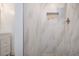 Tiled shower featuring a pebble stone floor and a marble tiled wall with a built-in cubby at 800 Everest Rd, Venice, FL 34293