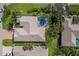 Overhead shot of a home with a screened-in pool area, surrounded by mature palm trees and lush green landscaping at 8861 17Th Avenue Nw Cir, Bradenton, FL 34209
