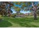 Lush backyard with a tranquil pond view, mature trees, and well-manicured lawn at 8861 17Th Avenue Nw Cir, Bradenton, FL 34209