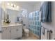 A bright and airy bathroom featuring a shower and vanity with seashell-themed decor and ample towel storage at 8861 17Th Avenue Nw Cir, Bradenton, FL 34209