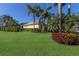 Well-maintained home exterior featuring a manicured lawn, tropical landscaping, and vibrant flower beds at 8861 17Th Avenue Nw Cir, Bradenton, FL 34209