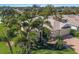 Aerial view of a beautifully landscaped home with mature palms, brick driveway, and lush greenery at 8861 17Th Avenue Nw Cir, Bradenton, FL 34209