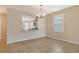 Open dining area featuring tile floors, a modern light fixture, and a pass-through to the kitchen at 8996 Excelsior Loop, Venice, FL 34293