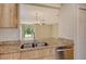 Granite countertops accent the open kitchen with stainless steel appliances and backyard views at 8996 Excelsior Loop, Venice, FL 34293