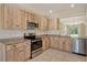 Stylish kitchen with stainless steel appliances, wood-look cabinets, and tile flooring at 8996 Excelsior Loop, Venice, FL 34293