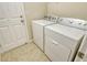 Laundry room features tile floors and a new white washer and dryer at 8996 Excelsior Loop, Venice, FL 34293