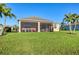 Lush green backyard featuring a screened-in patio, mature landscaping, and well-maintained lawn at 1014 Calico Gln, Bradenton, FL 34212