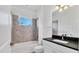 Modern bathroom featuring a shower-tub combo with sleek tile surround and a vanity with black countertop at 1014 Calico Gln, Bradenton, FL 34212
