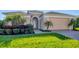 Charming single-Gathering home boasts an arched entrance, lush landscaping, and a well-maintained front yard at 1014 Calico Gln, Bradenton, FL 34212