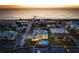 Aerial view of the home highlighting its waterfront location, a pool, a rooftop deck and nearby beach at 110 10Th S St, Bradenton Beach, FL 34217