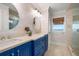 Bright bathroom featuring double sinks, granite counters, and blue vanity at 110 10Th S St, Bradenton Beach, FL 34217