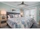 Stylish bedroom with light blue walls, ceiling fan, and access to a balcony at 110 10Th S St, Bradenton Beach, FL 34217