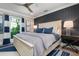 Bedroom with a dark accent wall, neutral bedding, and a ceiling fan at 110 10Th S St, Bradenton Beach, FL 34217