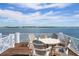 Stunning waterfront deck with white Adirondack chairs, offering panoramic ocean views and a serene outdoor space at 110 10Th S St, Bradenton Beach, FL 34217