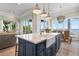 Kitchen island with ample seating, a farmhouse sink, and designer lighting, seamlessly connects to the living area at 110 10Th S St, Bradenton Beach, FL 34217