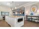 Kitchen island with barstool seating, pendant lighting, stainless oven, and adjacent living room at 110 10Th S St, Bradenton Beach, FL 34217
