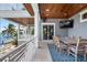 Covered outdoor dining area with waterfront views and comfortable seating for entertaining guests at 110 10Th S St, Bradenton Beach, FL 34217