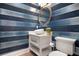 Stylish powder room with blue striped wallpaper, marble countertop, vessel sink, and modern toilet at 110 10Th S St, Bradenton Beach, FL 34217