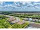 Aerial view showcases an expansive community with a mix of homes, trees, and scenic landscapes under a bright, cloudy sky at 13306 Deep Blue Pl, Bradenton, FL 34211