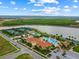 Aerial view of clubhouse with pools, tennis courts, and lake in a beautiful community at 13320 Coluccio St, Venice, FL 34293
