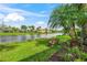 Scenic backyard with a bench overlooking a tranquil lake surrounded by lush greenery at 13320 Coluccio St, Venice, FL 34293