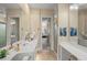 Bright bathroom featuring dual sinks, mirrors, and vanity, with a view into the primary bedroom at 13320 Coluccio St, Venice, FL 34293