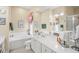 Bright bathroom featuring a double sink vanity, soaking tub, and decorative accents at 13320 Coluccio St, Venice, FL 34293