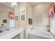 Bright bathroom featuring a vanity with lots of counter space, tub and decorations at 13320 Coluccio St, Venice, FL 34293