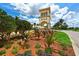 Decorative entrance fountain and well-maintained landscaping with a stone tower in the background at 13320 Coluccio St, Venice, FL 34293