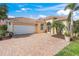Inviting home with a brick paver driveway, two-car garage, and lush landscaping at 13320 Coluccio St, Venice, FL 34293