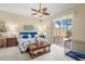 Cozy primary bedroom with ceiling fan and sliding glass doors to the patio at 13320 Coluccio St, Venice, FL 34293