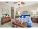 Bright primary bedroom featuring coastal decor, ceiling fan, and natural light at 13320 Coluccio St, Venice, FL 34293