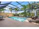 Inviting screened-in pool surrounded by palm trees and lush landscaping at 13320 Coluccio St, Venice, FL 34293