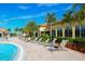 Beautiful pool area with lounge chairs, palm trees, and tropical landscaping, creating a serene outdoor retreat at 13320 Coluccio St, Venice, FL 34293
