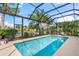Refreshing screened-in pool with a view of the lush tropical landscape at 13320 Coluccio St, Venice, FL 34293