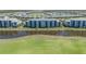 Aerial view of a light blue condo complex surrounded by lush green grass and a serene lake at 14061 Heritage Landing Blvd # 412, Punta Gorda, FL 33955
