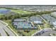 Aerial view featuring tennis and pickleball courts with lush landscaping and parking at 14061 Heritage Landing Blvd # 412, Punta Gorda, FL 33955