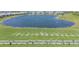 Aerial view of driving range with golfers practicing and lake views, part of a luxurious community at 14061 Heritage Landing Blvd # 412, Punta Gorda, FL 33955