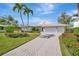 Stunning single-story home featuring a paved driveway and lush landscaping with palm trees at 1511 N Lake Shore Dr, Sarasota, FL 34231