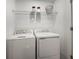 Functional laundry room with white washer and dryer, and wire shelving for storage at 15116 Cuzcorro Ct, Nokomis, FL 34275