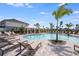 Inviting community pool featuring lounge chairs, cabanas and palm trees at 15116 Cuzcorro Ct, Nokomis, FL 34275