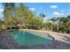 Backyard swimming pool surrounded by brick pavers and lush landscaping at 1855 Buccaneer Ct, Sarasota, FL 34231