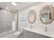 Bright bathroom with dual sinks, tiled shower, and decorative mirrors at 1876 Livingstone St, Sarasota, FL 34231