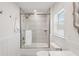 Bright bathroom features a shower with glass door and white tiled walls and white cabinets at 1876 Livingstone St, Sarasota, FL 34231