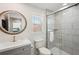 Well-lit bathroom with a glass-enclosed shower, sink, toilet and a decorative mirror at 1876 Livingstone St, Sarasota, FL 34231