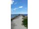 Concrete pier stretching out over blue water on a sunny day with puffy clouds at 1876 Livingstone St, Sarasota, FL 34231