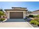 A well-lit two-car garage features a clean driveway and meticulously maintained landscaping at 1876 Livingstone St, Sarasota, FL 34231