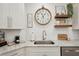 Well-appointed kitchen featuring marble countertops, a stainless steel sink, and white cabinetry at 1876 Livingstone St, Sarasota, FL 34231